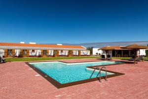 a swimming pool in front of a building at Monte do Zeca in Zambujeira do Mar