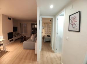 a white living room with a couch and a table at Apartamento Casa Bielsa in El Pueyo de Jaca
