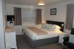 a bedroom with a large bed and a window at Tirah Guest House in Aldeburgh