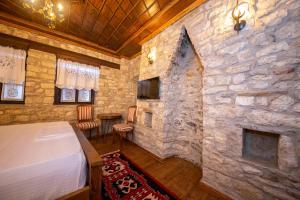 Berati Castle Hotel في بيرات: غرفة نوم بحائط حجري وسرير في غرفة