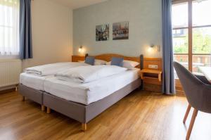 a bedroom with a large bed and a desk at Hotel am Schwanberg in Rödelsee