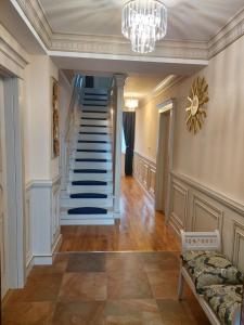 a hallway with a staircase in a home with a chandelier at Sky Park Home in Iaşi