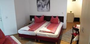 sypialnia z łóżkiem z czerwonymi poduszkami w obiekcie Apartmenthaus beim LKH Graz w Grazu
