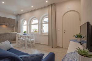 een woonkamer met een blauwe bank en een keuken bij La casetta in collina in Valeggio sul Mincio
