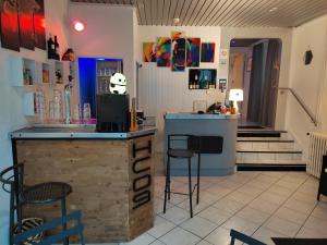 un bar dans un restaurant avec un comptoir et des tabourets dans l'établissement Hôtel Confort 09 ou HC-09, à Tarascon-sur-Ariège