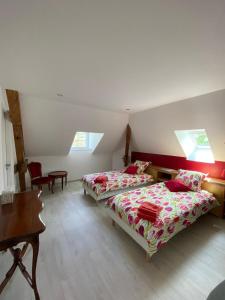 アルク・エ・スナンにあるChambres d'hôtes Le Petit Rocheのベッドルーム1室(ベッド2台、テーブル、デスク付)