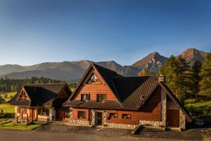 a wooden house with mountains in the background at Pension Vasko in Ždiar