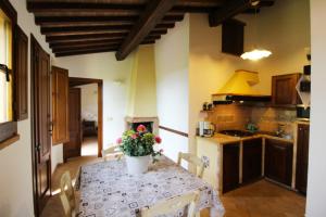 una cucina con tavolo e vaso di fiori di Casa Cervognano a Montepulciano