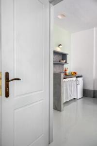 a white door in a kitchen with a table at Coralli Seaside Resort in Livadakia