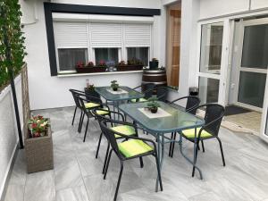 due tavoli e sedie su un patio con piante di Silver Apartman a Eger