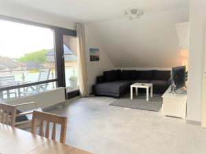 a living room with a couch and a television at Ferienwohnung am Teutoburger Wald 2 in Oerlinghausen