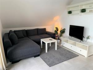 een woonkamer met een bank en een tv bij Ferienwohnung am Teutoburger Wald 2 in Oerlinghausen