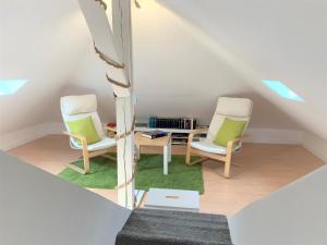 a attic room with two chairs and a table at Ferienwohnung am Teutoburger Wald 2 in Oerlinghausen