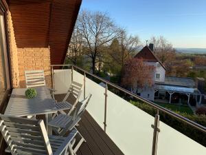 einen Balkon mit zwei Stühlen und einem Tisch darauf in der Unterkunft Ferienwohnung am Teutoburger Wald 2 in Oerlinghausen
