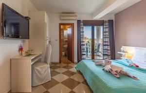 a bedroom with a television and a bed with a chair at Villa San Rocco Bed & Breakfast in Medulin
