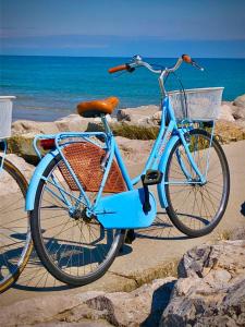 una bici blu parcheggiata sulla spiaggia vicino all'oceano di Hotel Paolina a Lido di Jesolo