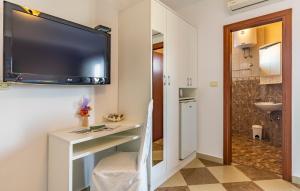 a room with a tv on the wall and a bathroom at Villa San Rocco Bed & Breakfast in Medulin