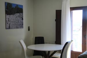 einen weißen Tisch und Stühle in einem Zimmer mit Fenster in der Unterkunft Lapiaz in Mosqueruela