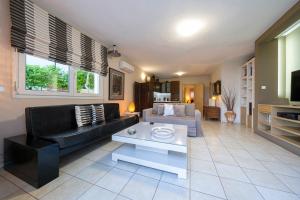 a living room with a couch and a table at Sea Path Apartment in Paleo Tsifliki