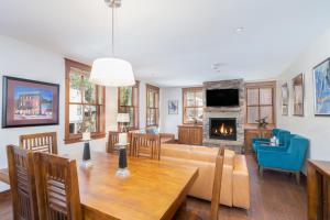 a living room with a table and a couch and a fireplace at Ballard North in Telluride