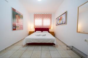a bedroom with a bed with a red head board at Sea Path Apartment in Paleo Tsifliki