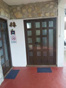 a pair of doors on a house with a red floor at Guesthouse Bajka in Vinci