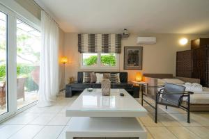 a living room with a couch and a table at Sea Path Apartment in Paleo Tsifliki