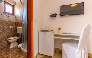 a bathroom with a toilet and a television on the wall at Villa San Rocco Bed & Breakfast in Medulin