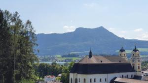 Ferienwohnung am Mondsee في موندزي: مبنى كبير فيه برجين وجبل في الخلفية