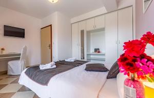 a bedroom with a large bed with red flowers in a vase at Villa San Rocco Bed & Breakfast in Medulin