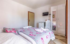 a white bedroom with a bed with a flowered blanket at Villa San Rocco Bed & Breakfast in Medulin