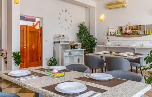 a dining room with a table and chairs and a clock at Villa San Rocco Bed & Breakfast in Medulin