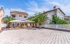 a house with a white fence and palm trees at Villa San Rocco Bed & Breakfast in Medulin