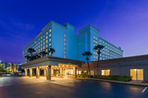 un gran edificio azul con palmeras delante en Holiday Inn & Suites Across From Universal Orlando, an IHG Hotel, en Orlando