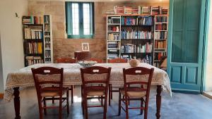 a dining room with a table and chairs and bookshelves at Landolina Guest House in Donnalucata +14 photos