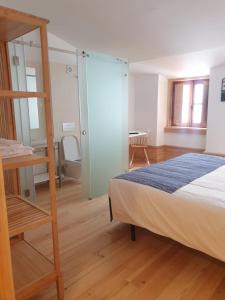 a bedroom with a bed and a glass wall at Casa da Baixa Downtown House in Coimbra