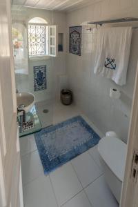 een witte badkamer met een toilet en een wastafel bij The Admiral's House Kastellorizo in Meyisti
