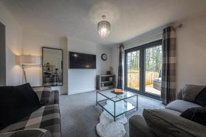 a living room with a couch and a glass table at Modern 2 Bedroom House in Portree