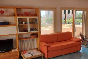 a living room with an orange couch and a tv at In Vacanza a Gaeta - Villa Marianna in Gaeta