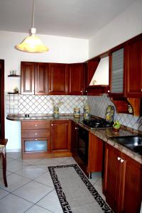 a kitchen with wooden cabinets and a stove top oven at Da Lorenzo Apartment in Gaggi