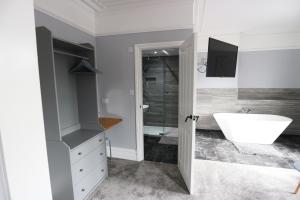 a bathroom with a white tub and a sink at Number 33 Room Only in Whitby