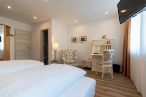 1 Schlafzimmer mit 2 Betten, einem Schreibtisch und einem Stuhl in der Unterkunft Hotel-Restaurant Schettel in Olsberg