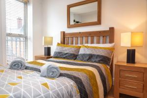 a bedroom with a bed and two lamps and a mirror at The Old Library - Modern apartment with rooftop terrace near the train station in Newbury