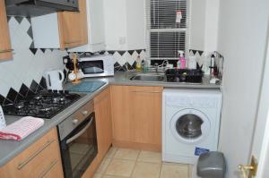 uma cozinha com um lavatório e uma máquina de lavar roupa em Kirk View holiday apartment em Kirkcaldy