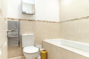 a bathroom with a toilet and a bath tub at The Old Library - Modern apartment with rooftop terrace near the train station in Newbury