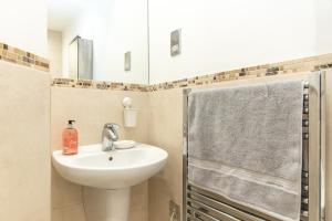 a bathroom with a sink and a shower at The Old Library - Modern apartment with rooftop terrace near the train station in Newbury