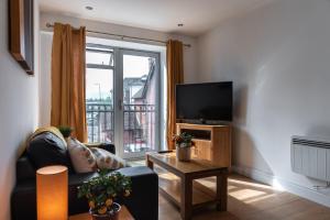 a living room with a couch and a flat screen tv at The Old Library - Newbury Town Centre - Within easy reach of Train Station and Racecourse - Excellent road links via the A34 and M4 in Newbury +33 photos