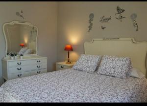 拉瓦納爾德爾卡米諾的住宿－LA CASONA DE RABANAL，一间卧室配有一张床、梳妆台和镜子