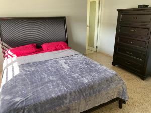 a bedroom with a large bed and a dresser at La Casona Beach House in Fajardo