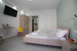 a bedroom with a bed and a tv on the wall at Monolocale in centro a due passi dal mare in San Vito lo Capo